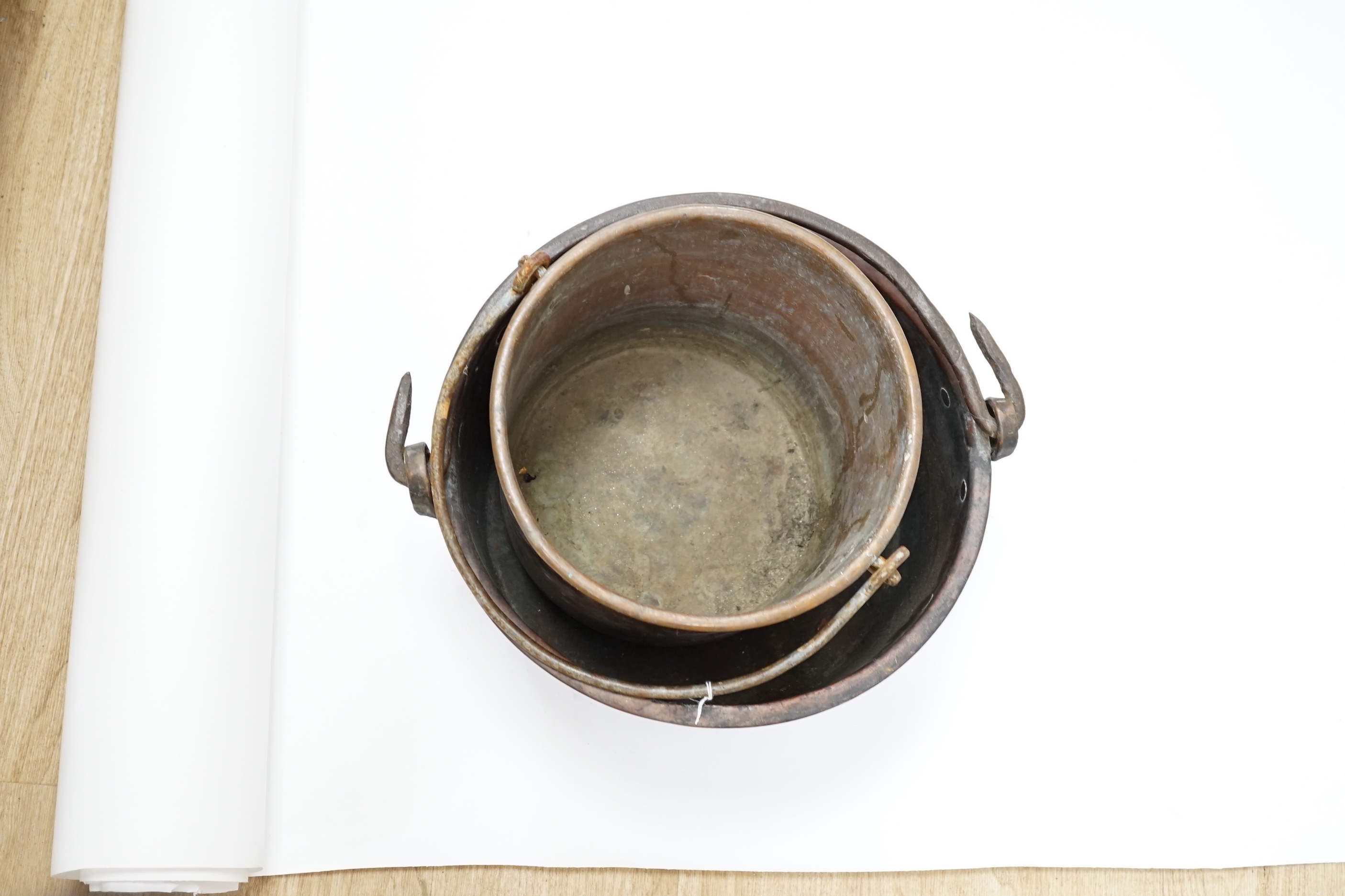 Two copper cauldrons with swing handles, the largest 43cm wide